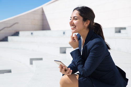 A woman holding a smart phone thinking about her future