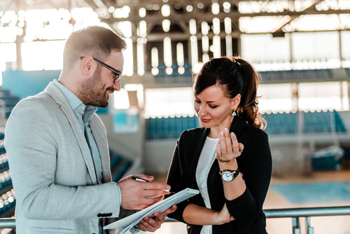 Two colleagues consulting a clipboard at a swimming pool