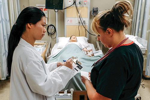 A nursing student taking notes on a patient
