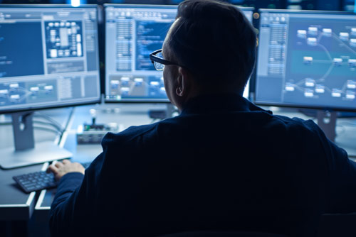 A man working at multiple security terminals